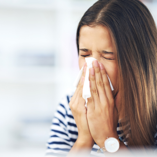 Someone blowing their nose in a tissue